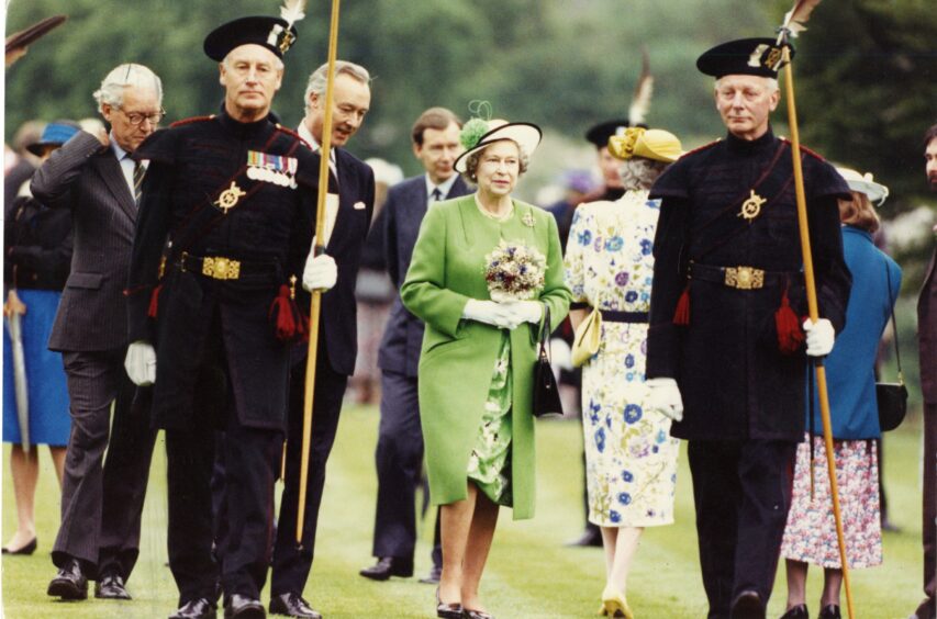 The Monarch and the Marquis of Bute flanked by members of the Queen's bodyguards in Scotland, the Royal Company of Archers, at Falkland Palace