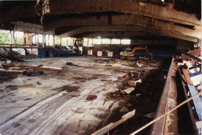 A digger can be seen clearing debris from the floor after the main stadium was pulled down.
