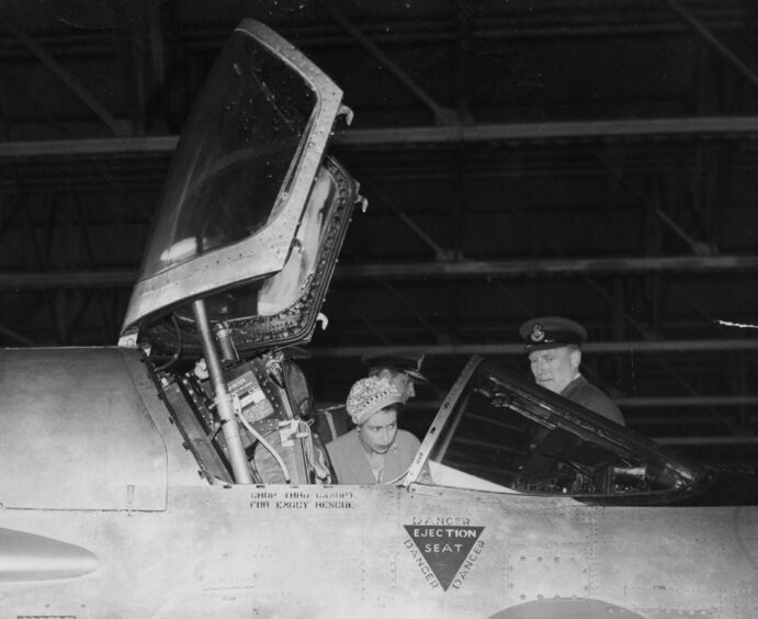 Queen Elizabeth II looks into the cockpit of the P1 Hawker Hunter, one of the latest British fighter planes, during her visit to RAF Leuchars, Fife, Scotland.