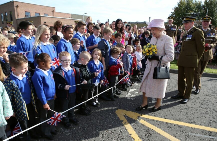 Queen Elizabeth II meets pupils from Leuchars Primary School during a visit to The Royal Scots Dragoon Guards' barracks in 2015. 