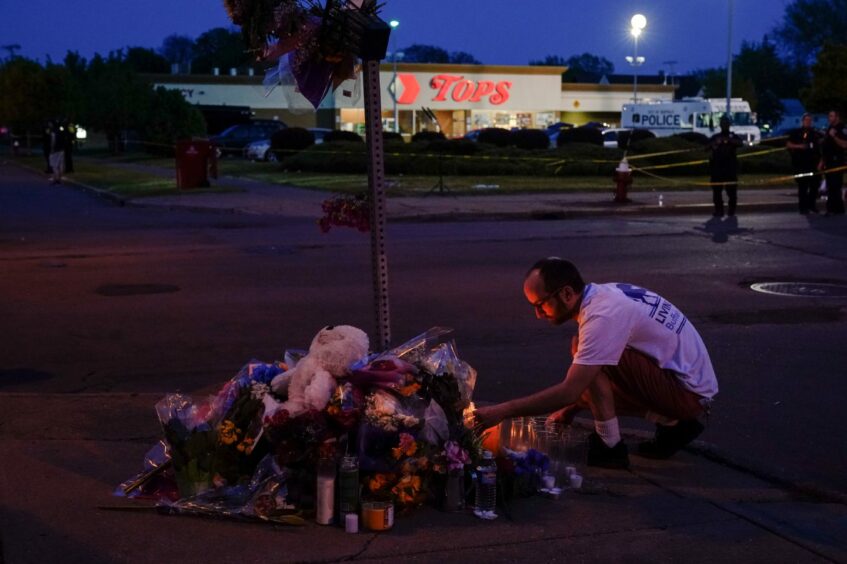 A person pays his respects outside the scene of a shooting at a supermarket, in Buffalo, N.Y. AP Photo/Matt Rourke.