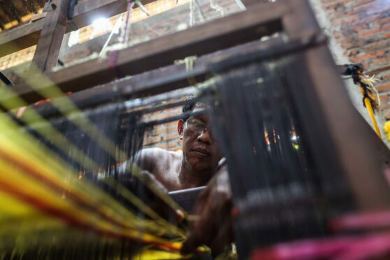 A worker weaver making textiles at the traditional weaving workshop at Troso village in Jepara, Central Java Province, Indonesia.