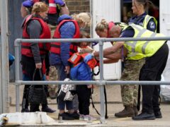 A young child is helped amongst a group of people thought to be migrants as they are brought in to Dover, Kent (Gareth Fuller/PA)