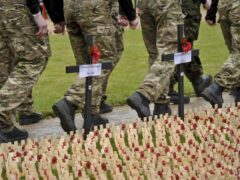Soldiers march past crosses (Ben Birchall/PA)