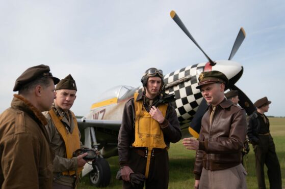 Spirit of Britain living history group dressed as American Second World War aircrew with TF-51D Mustang 'Contrary Mary' during the annual Duxford Summer Air Show in Duxford, Cambridgeshire. Joe Giddens/PA Wire.