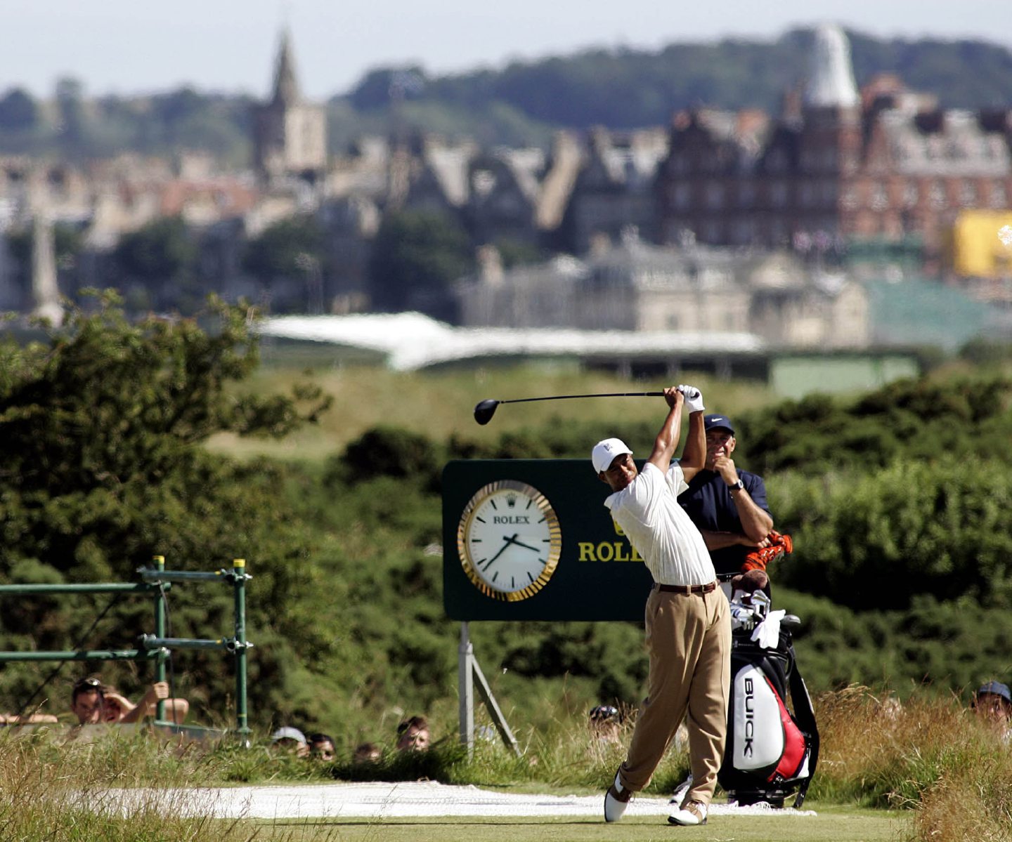 Tiger Woods tees off from the sixth during a practice round with St Andrews in the background.