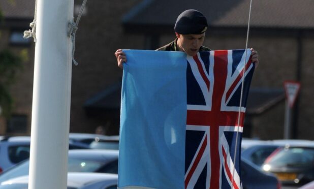 The flag is taken down from half mast at RAF Lossiemouth airbase in the wake of the 2012 collision.