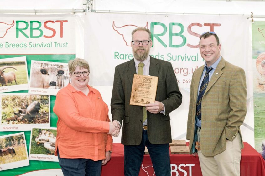 Rare Breeds Survival Trust chairman shaking hands and standing next to two award-winners