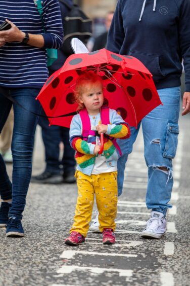 Bess Hamilton walks through Pride with her umbrella.