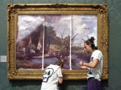 Protesters from Just Stop Oil climate protest group, cover John Constable’s The Hay Wain with their own picture at the National Gallery, London (PA)