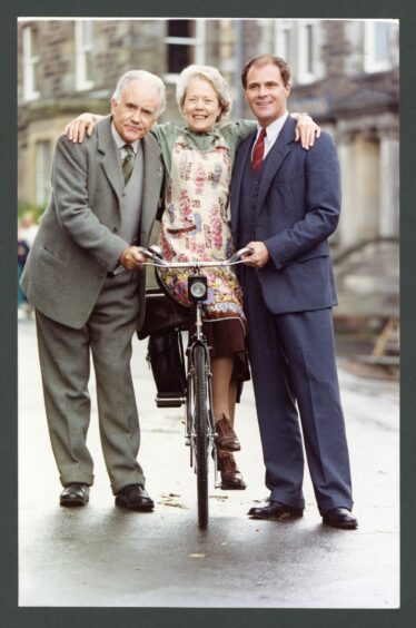 Ian Bannen, Annette Crosbie and David Rintoul get on their bike in Auchtermuchty in 1992.