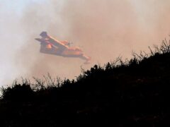 A firefighting airplane over a wildfire near Alcublas in eastern Spain (Alberto Saiz/AP)
