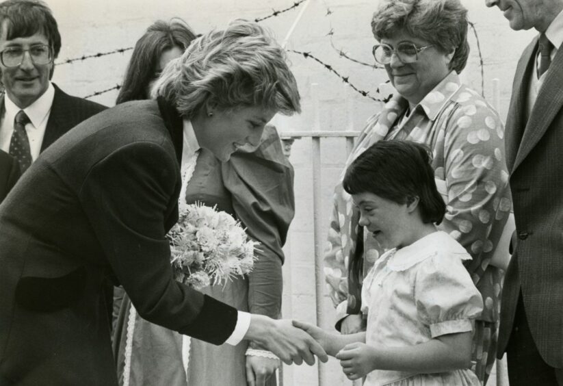 Princess Diana greeting a young girl during her visit to Dr Barnardo's in Dundee in 1986.