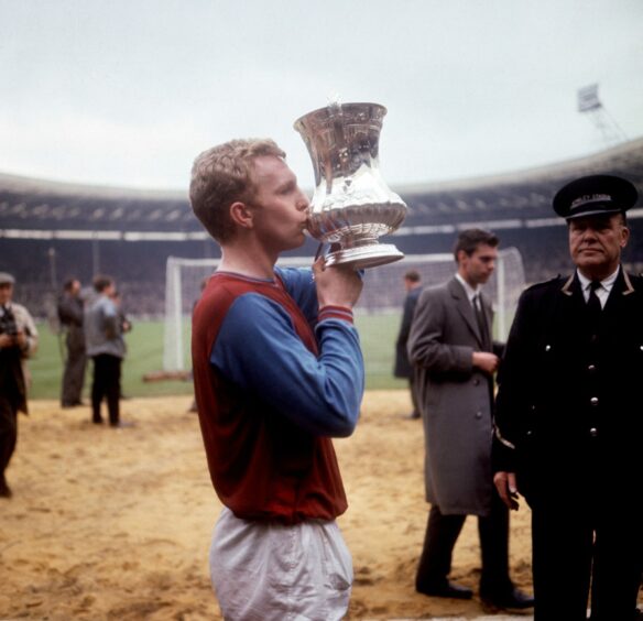 West Ham United captain Bobby Moore kisses the FA Cup in celebration after his team's 3-2 victory in 1964.