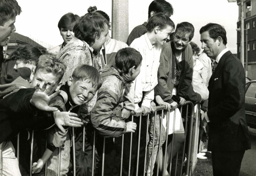 The future king talking to a crowd of young people during his walkabout.