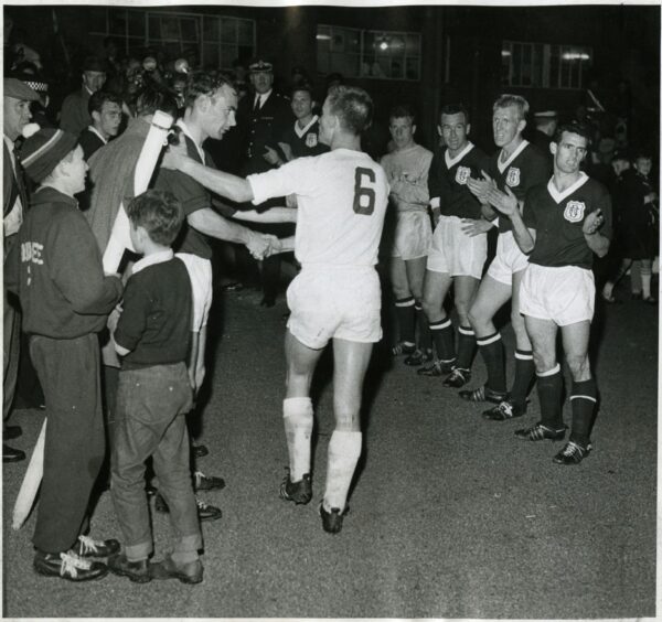 Gilzean shakes hands with Helmut Benthaus as the Dundee FC team applaud the Germans into the dressing room.