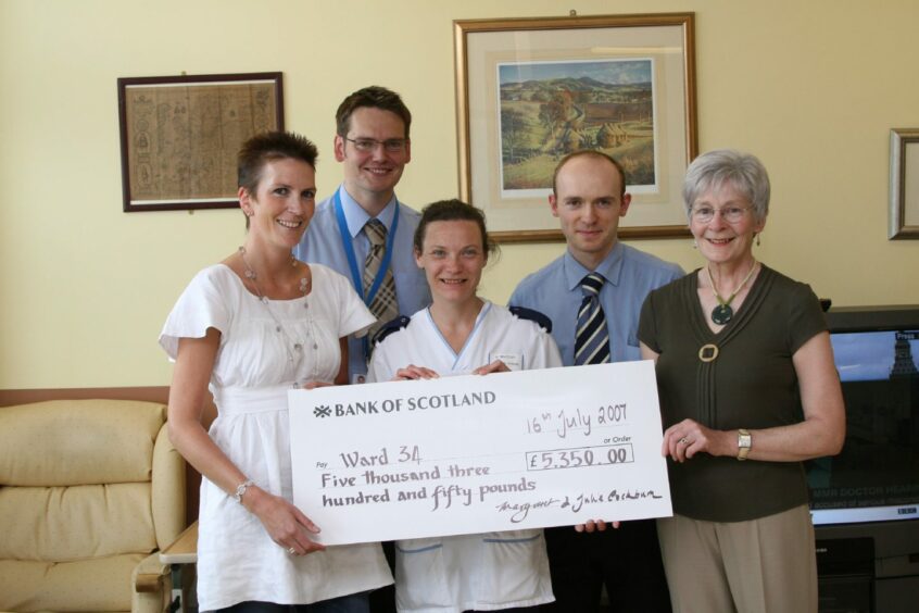 Julie and Margaret Cockburn present a cheque to charge nurse Heather Whatley (centre) as Dr Ian Sanders and Dr Gordon Harron look on at Ninewells Hospital.