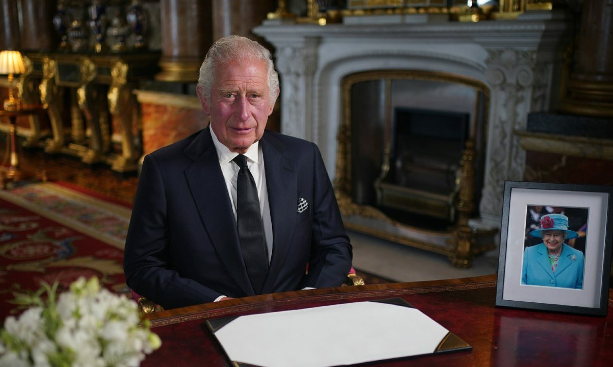 Image of King Charles III.  at a desk in Buckingham Palace