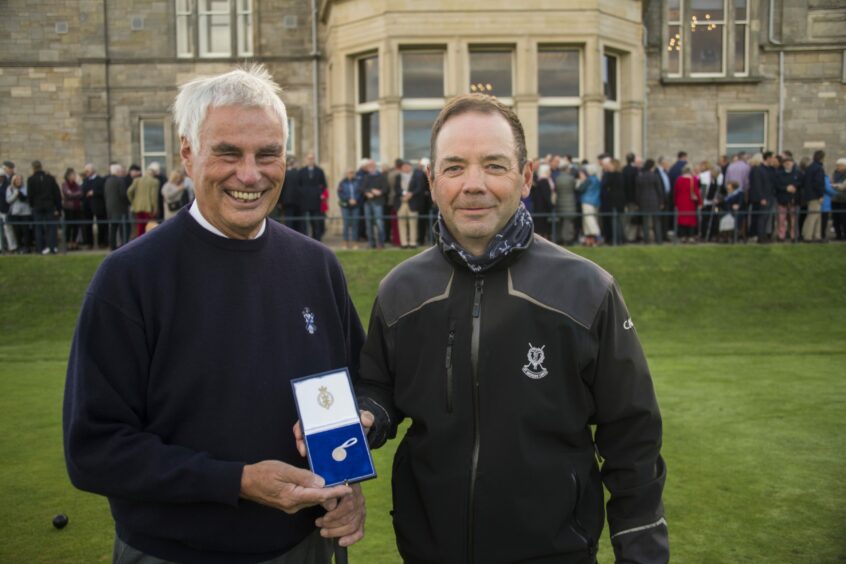 Caddie Martin O'Brien receives his gold sovereign from Mr Brown.