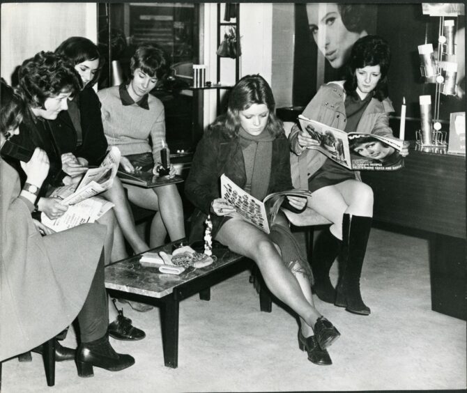 These ladies of the Elite Hair Fashions shop in Montrose had a fair old read by candle light while waiting for the electric power to be restored in 1972.