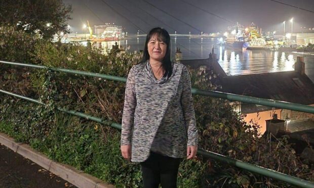 Michelle Fletcher standing in front of the harbour at night. 
