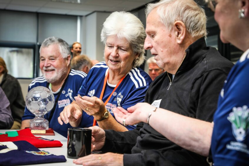 Maureen Phillips looks at Ian Ure's league medal during the special event