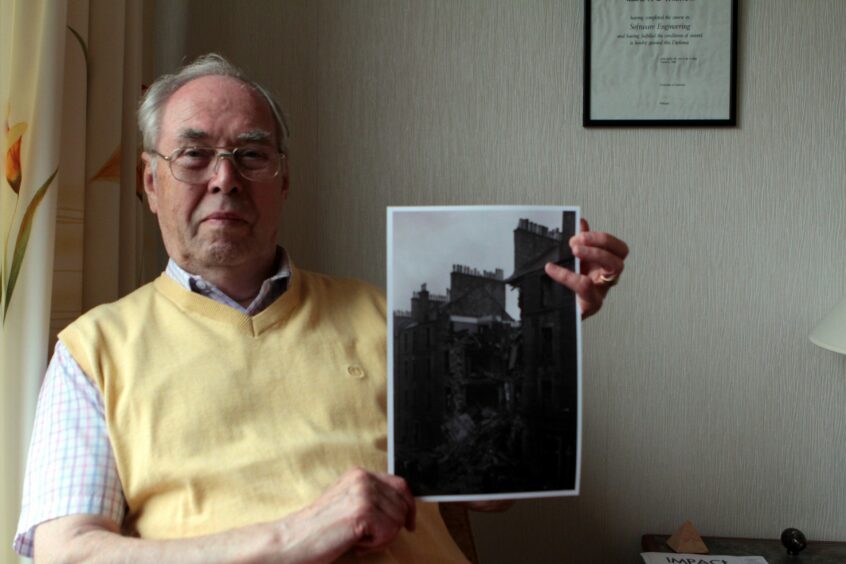 George Wilmott holding an image of the tenement.