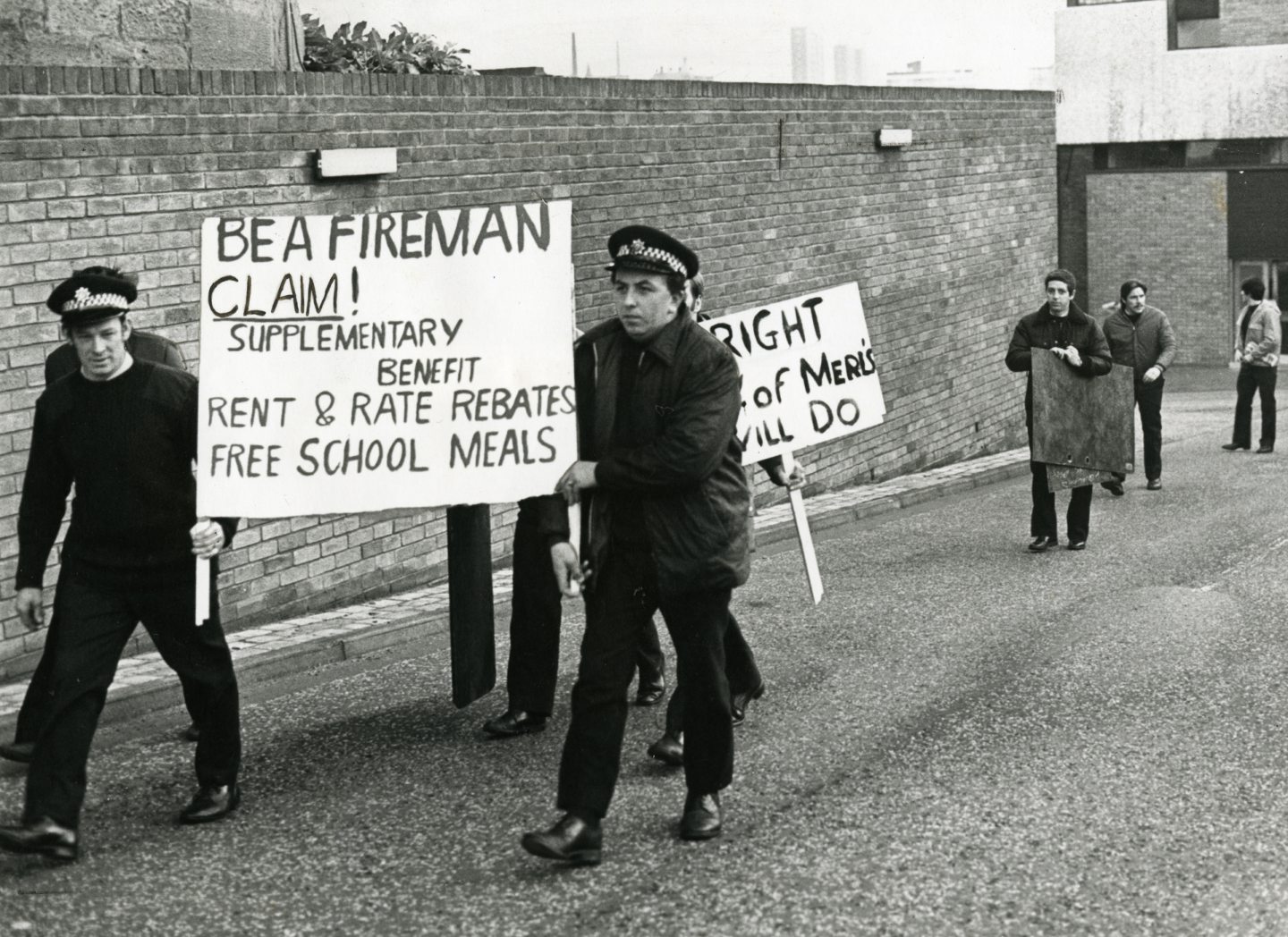 Firemen finish their last shift before strike then walk out sign demanding better rights in 1977.