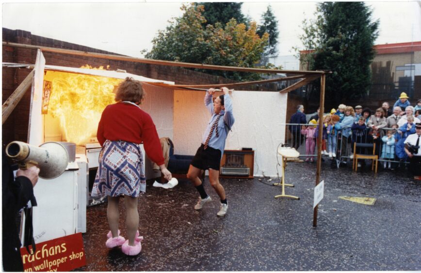 Firemen acting out the dangers of a chip pan fire at the Kingsway East fire Station open day, September 1990.