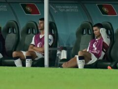 Portugal’s Cristiano Ronaldo, right, sits on the bench (Hassan Ammar/AP)
