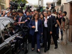 Peru’s new President Dina Boluarte walks to her car after speaking to the press as she leaves her home in Lima, Peru (Martin Mejia/AP/PA)