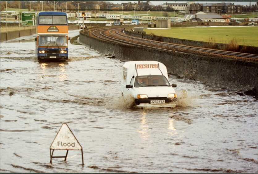 A bus and a van driving through a flooded area in Arbroath. Image: DC Thomson.