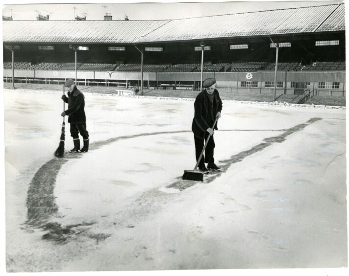 Dundee FC groundsmen sweeping snow from Dens Park on January 17 1963