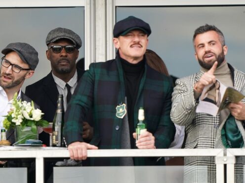 Idris Elba (second left) watches from a balcony, behind Luke Evans and Fran Tomas on day four of the Cheltenham Festival at Cheltenham Racecourse (Joe Giddens/PA)