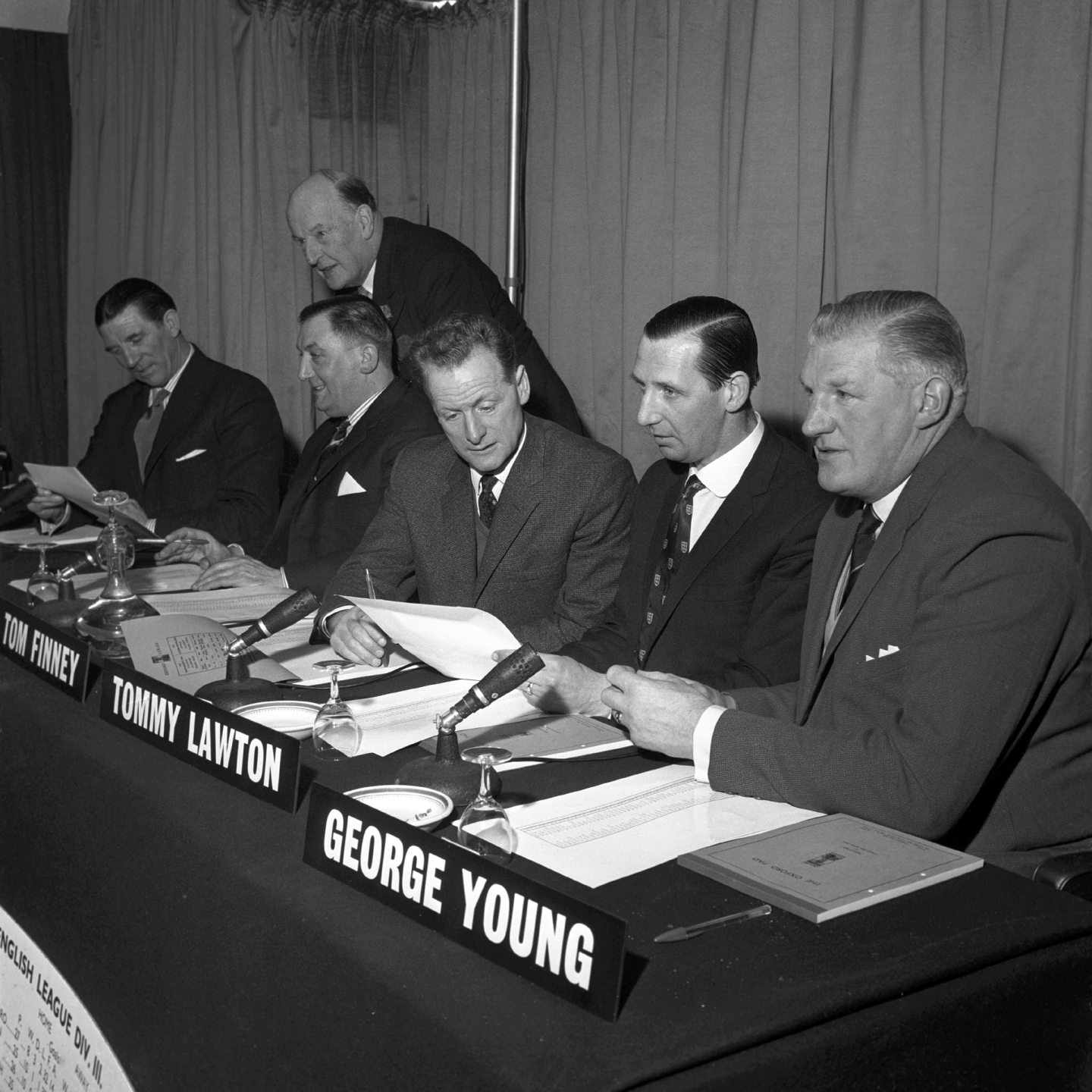 Lord Brabazon of Tara, the 78 year old chairman, looks over the shoulders of the three men of the panel. Image: PA.