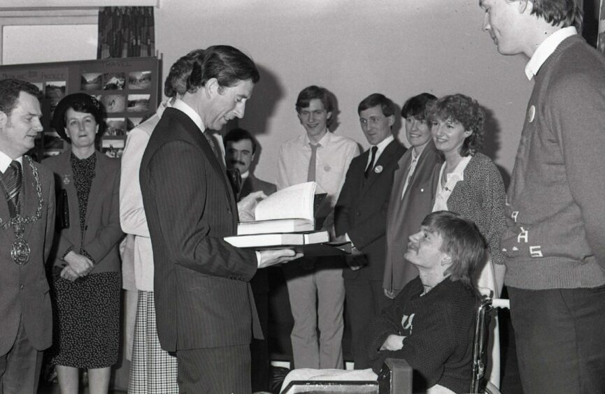 Dundonian disabled poet Thomas Malone hands over some of his work. Image: DC Thomson.