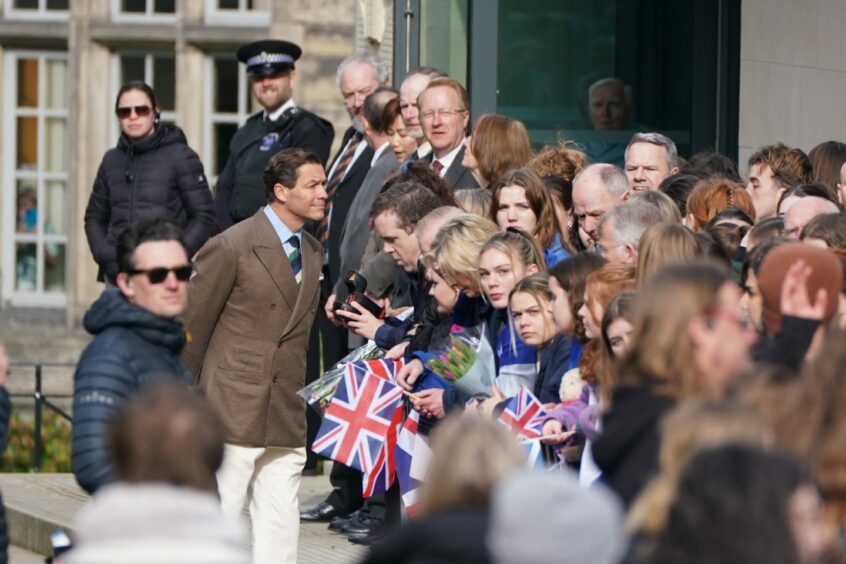 The Prince of Wales, played by Dominic West, interacting with crowd, played by background actors, during the filming of The Crown in St Andrews.