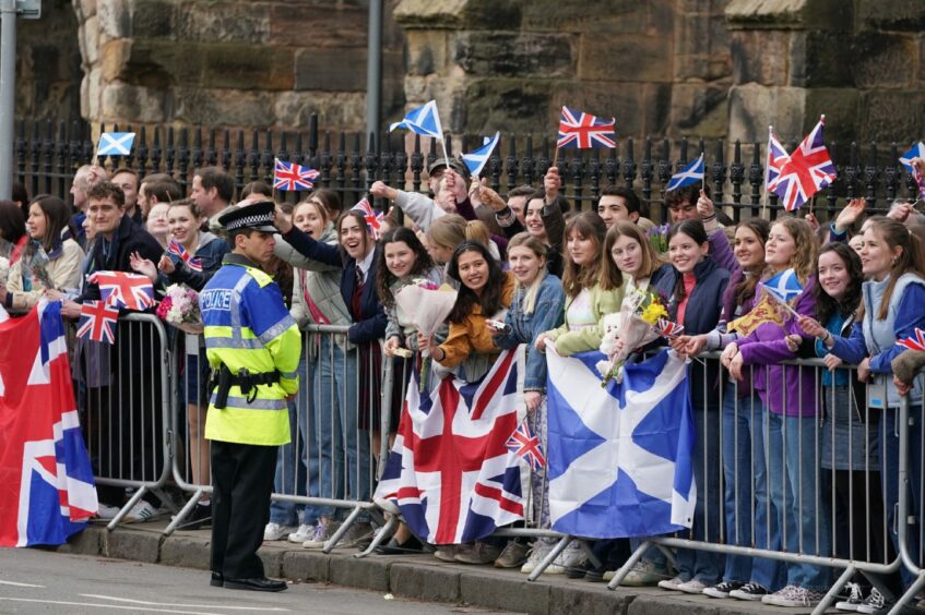 Background actors playing onlookers awaiting the arrival of the Prince during the filming of season six of Netflix series The Crown in St Andrews, Scotland.