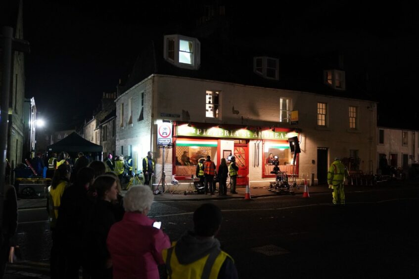 Members of the public gathered outside the Pizzeria in St Andrews to watch the filming of season six of The Crown.
