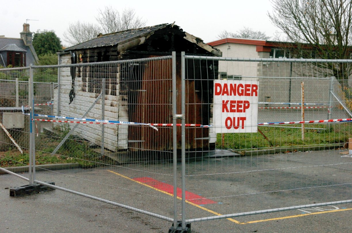 Fences surrounding the Inverurie Academy garage after it was set on fire in 2004 with signs reading: Danger Keep Out. 