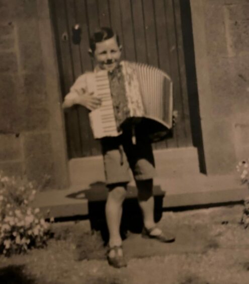 Bruce Sturrock as a boy playing the accordion.
