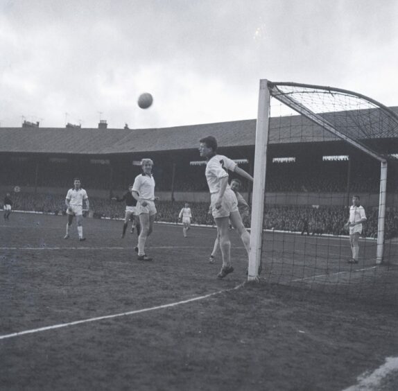 A Dundee player heads the ball clear of goal.
