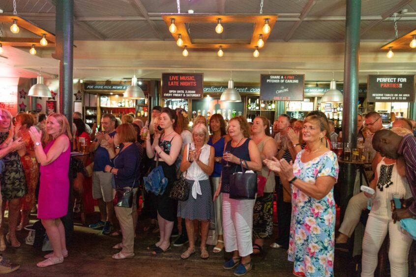 A crowd watches Funk Connection playing in Clark's Bar at 2018's Almost Blue festival.