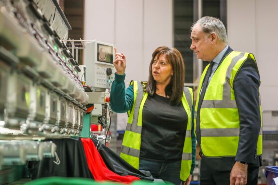 Joyce Gibson, owner and director of Direct Soccer, shows Richard Lochhead around the warehouse.