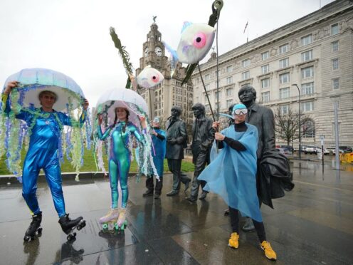 Performers dressed as jellyfish on roller skates skate around the Beatles statue at the launch of Eurovision EuroFestival (Peter Byrne/PA)