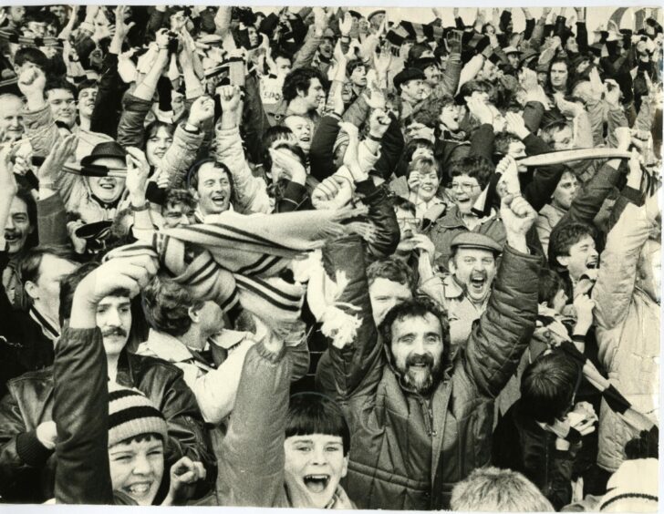 Dundee United fans cheer their heroes to victory from the Dens Park terraces in 1983. Image: DC Thomson.