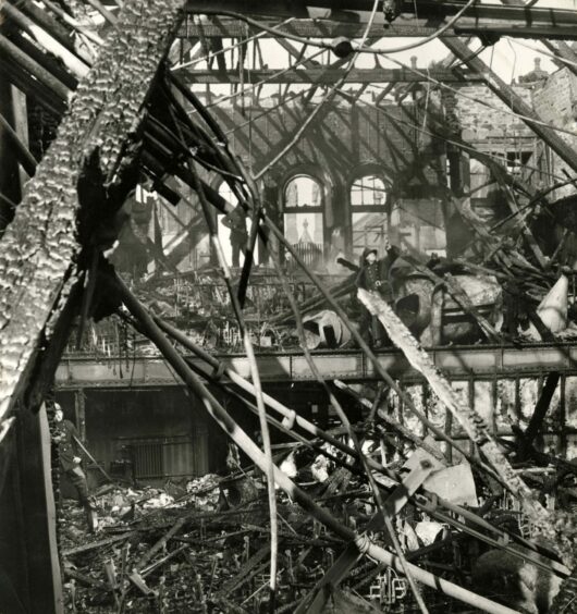 A firefighter can be seen on the balcony in the stricken building on June 1 1963. Image: DC Thomson.