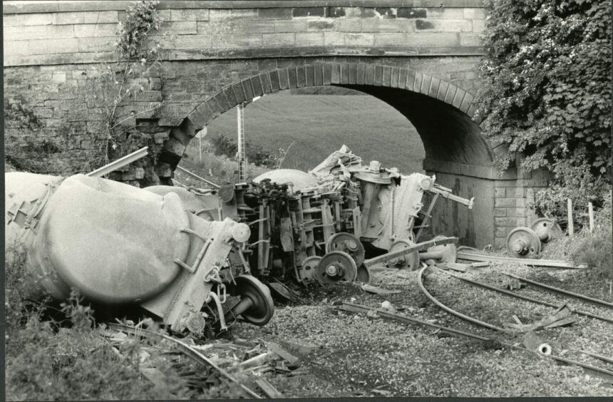The cement wagons are stricken beside the tracks following the accident. Image: DC Thomson.