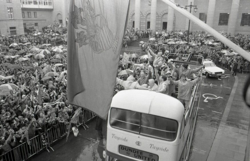 The players on the open top bus in City Square, with fans looking on. 