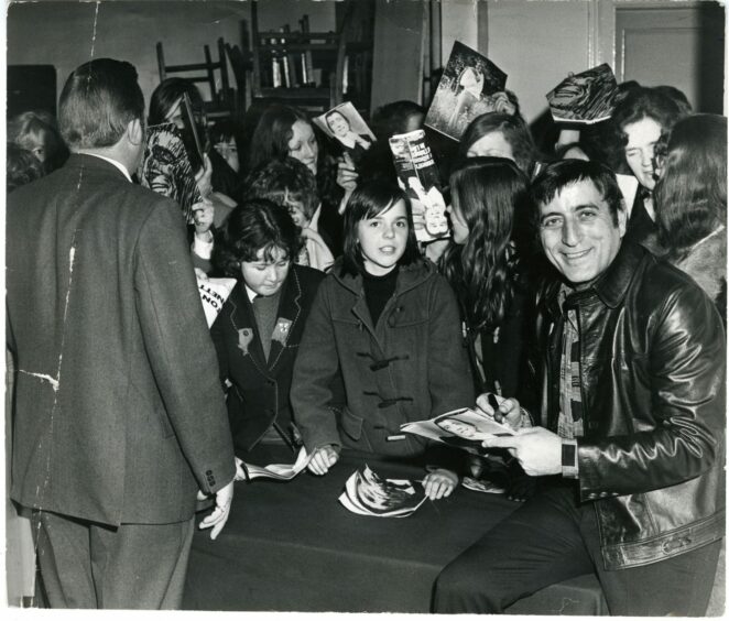 Tony Bennett, signing autographs, proved he was a man of the people after his show on March 16 1973. Image: DC Thomson.